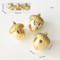 Three golden acorn Christmas ornaments with glitter tops and white snowflake patterns - Hazelnut Pendant (Gold)