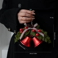 Gedetailleerd beeld van 18cm kerstklokken met rode bessen, dennenappels en geruite strik - Rode Bel