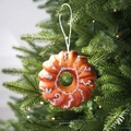 Glazed donut Christmas ornament with colorful sprinkles on a festive tree background - Doughnut H