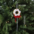 Adorno de Navidad tipo donut marrón con glaseado blanco y lazo rojo colgado en árbol - Paleta