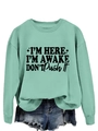 Detail of mint green sweatshirt with I'm Here slogan and distressed denim shorts - Light Green (Black Text)