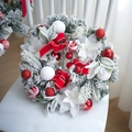 Beschneiter Weihnachtskranz mit roten Schleifen und weißen Weihnachtssternen auf Stuhl - Rot-weißer Kranz