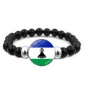Elastic beaded bracelet featuring black onyx beads and Lesotho flag glass pendant - Lesotho