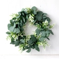 Corona de eucalipto artificial con flores blancas sobre fondo de puerta de madera - Estilo Floral Blanco de Eucalipto