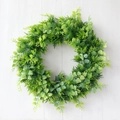 Artificial green fern wreath in round shape for front door hanging on white wood - Green Fern Plant Style