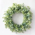 Artificial eucalyptus wreath with white berries on a white wood wall backdrop - Lush Green Eucalyptus White Flower Style