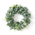 Artificial eucalyptus wreath with white berries on a white wood textured background - Sage Green Eucalyptus White Flower Style