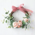 Artificial flower wreath with peach tulips, eucalyptus and striped bow on wood - Pink Ranunculus Rattan Style