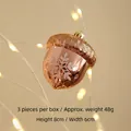 Tres adornos de bellota en oro rosa con copos de purpurina blanca para Navidad - Avellana Rosa