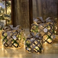 Three-piece gold lighted Christmas gift boxes with warm LED lights and pine cone accents - Star Gift Box Style