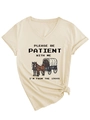 Close-up of beige V-neck T-shirt featuring vintage carriage print and tied hem detail - S / Sand