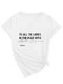 Dettaglio della t-shirt bianca con scollo a V, testo grafico nero e nodo decorativo sull'orlo - S / Bianco (Carattere Nero)