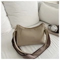 Detail of beige crossbody pillow bag with wide patterned strap on white fabric - Khaki