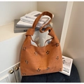 Dettaglio del motivo floreale traforato e manico a nodo su borsa hobo in pelle scamosciata - Marrone