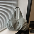 Large capacity sage green nylon tote bag for women shown in a modern office desk setting - Blue