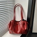 Elegante borsa tote in vernice rossa con fiocco e coulisse su un davanzale della finestra - Rosso