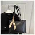 Detail der schwarzen Leder-Shopper-Tasche mit elegantem Seidenschal am Tragegriff - Schwarz