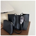 Detail van zwarte shopper-set met bijpassend tasje en zijden sjaal op een houten tafel - Zwart