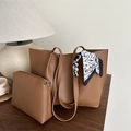 Caramel faux leather tote bag with silk scarf detail and inner pouch on wooden desk - Tan