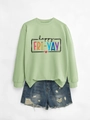 Detail of happy fri-yay print on mint green sweatshirt with distressed denim shorts - Olive Green Sweatshirt (Black Text)