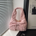 Rosa gesteppte Schultertasche mit großer Schleife auf einem sonnigen Fensterbrett - Rosa