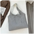 Detail of gingham canvas tote bag with bow tie and floral lining on a lifestyle background - Black Reverse