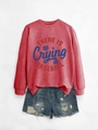 Dettaglio della felpa rossa con testo baseball e pantaloncini in denim con orlo a frange - Rosso