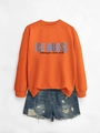 Detail of orange ICU NURSE sweatshirt paired with distressed denim shorts - Orange (Black Print)