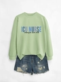 Detail of light green ICU NURSE sweatshirt paired with distressed denim shorts set - Olive Green (Black Print)