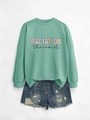 Flat lay of a mint green Radiation Therapist sweatshirt with distressed denim shorts - Light Green Sweatshirt (Black Text)