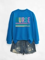 Détail d'un sweat bleu infirmière avec texte caring loyal strong et short denim - S / Bleu Lac