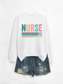 Detail of white long-sleeve sweatshirt with colorful Nurse typography and distressed denim shorts - White