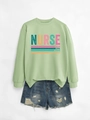 Detail of light green nurse sweatshirt with caring loyal strong print and denim shorts - Olive Green