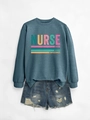 Close-up of nurse sweatshirt with caring loyal strong text and ripped denim shorts - Blue