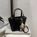 Contrast color embossed bucket bag with butterfly pattern and mini monster pendant charm - Black With Pendant
