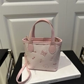 Pink mini crossbody bucket bag with embossed butterfly and puppy patterns and gold hardware - Pink
