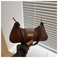 Close-up of brown half-moon baguette bag with knot strap and gold metal hardware - Brown