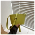 Primer plano de un bolso bombonera de cuero verde lima con hebilla y logo grabado - Verde