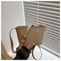Detail of a beige PU leather bucket bag featuring embossed logo and adjustable strap - Khaki