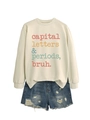 Flat lay of cream crewneck sweatshirt with slogan and distressed denim shorts set - Sand