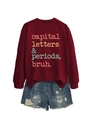 Flat lay of a dark red sweatshirt with 'capital letters' text and ripped denim shorts - Burgundy