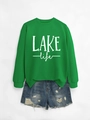 Détail du sweat-shirt vert clair LAKE life avec un short en jean bleu délavé usé - S / Sweat-shirt Vert Herbe (Imprimé Blanc)