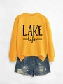 Close-up of ginger yellow LAKE life crewneck sweatshirt with distressed denim shorts - Yellow Sweatshirt (Black Print)