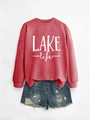 Close-up of brick red long sleeve sweatshirt with white LAKE life lettering and denim shorts - Red Sweatshirt (White Print)