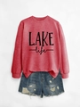 Flat lay of red LAKE life sweatshirt with ribbed cuffs and blue distressed denim shorts - Red Sweatshirt (Black Print)