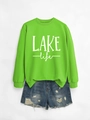 Detail of neon green crewneck sweatshirt with LAKE life text and denim shorts - Neon Green Sweatshirt (White Print)