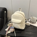 Retro cream-white PU leather mini backpack with luxury pendant on a dark wooden table - White With Pendant
