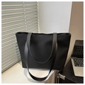 Dettaglio della borsa tote intrecciata nera con manici in pelle in ufficio - Nero