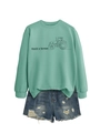 Flat lay of a mint green sweatshirt with tractor print and distressed denim shorts - Light Green (Black Print)