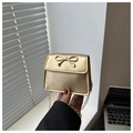 Detailed close-up of a gold bow-knot saddle bag with a metallic chain and buckle - Gold